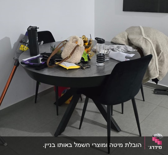 שולחן עם חפצים שונים, כולל תיק ובקבוק מים